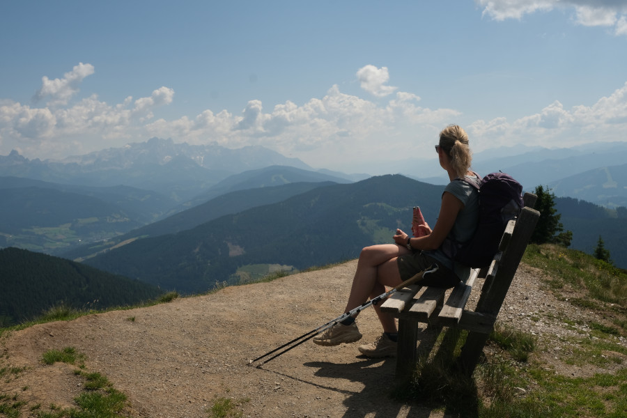Maaike geniet van het uitzicht vanaf een bankje op de top van Hochgründeck in St Johann im Pongau © bergfamilie.nl | Frank van Delden